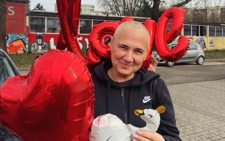 Kobieta trzymająca balony w kształcie serca i figurkę łabędzia.