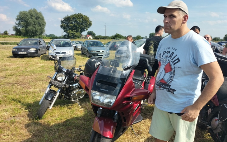 Mężczyzna przy motocyklu na zjeździe motocyklowym.
