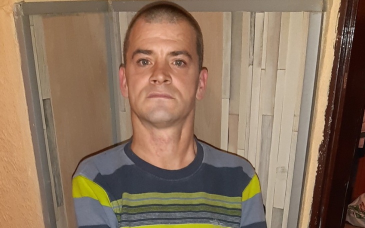 Mężczyzna w kolorowej koszulce, pozujący do zdjęcia.