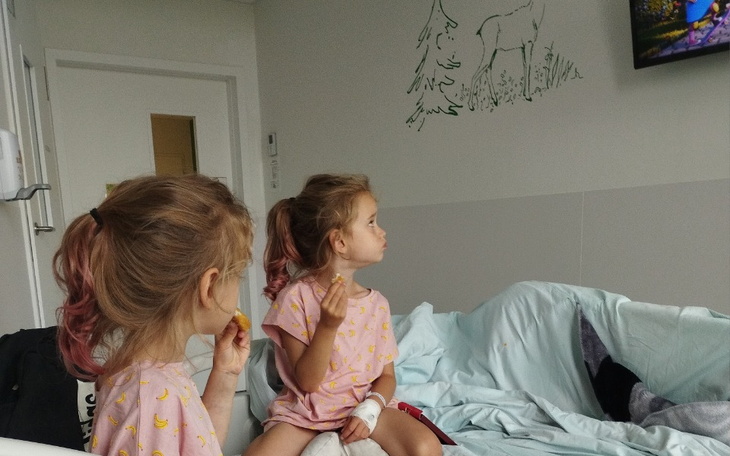 Dwie dziewczynki w szpitalu, oglądające telewizję.