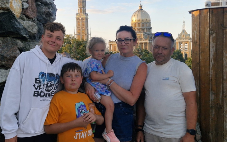 Rodzina na tle zabytkowej kopuły i dziedzińca, spontaniczne zdjęcie.