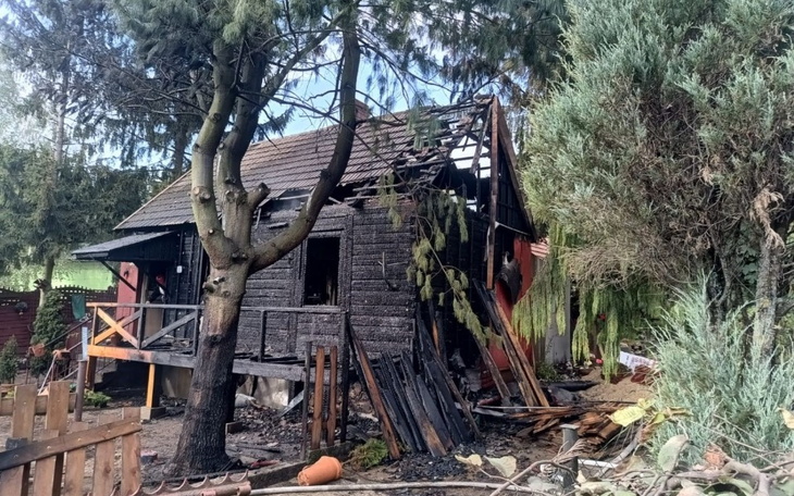 Zniszczony dom po pożarze, z widocznymi uszkodzeniami.