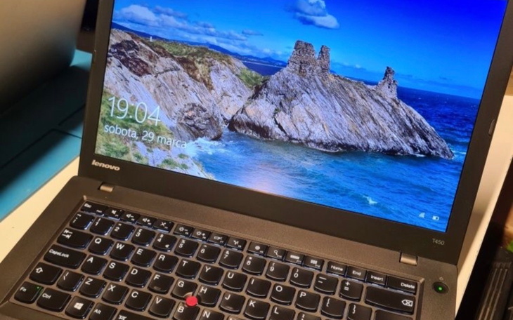 Laptop z widokiem na plażę na ekranie, gotowy do pracy.