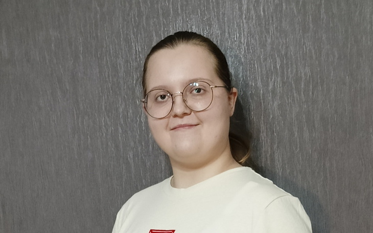 Młoda kobieta z okularami, uśmiechająca się do kamery.