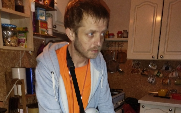 Mężczyzna w kuchni, skupiony na czymś.