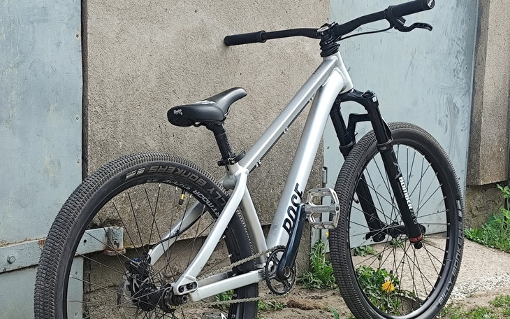 Srebrny rower górski z czarnymi elementami.