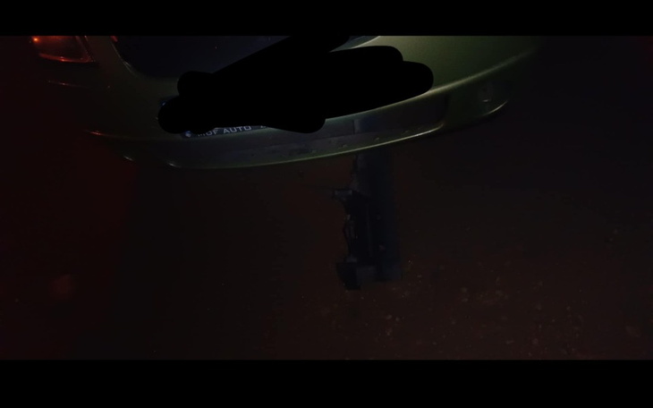 Zielony samochód zaparkowany w nocy, widoczny z tyłu.