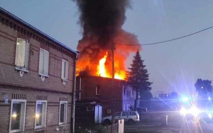 Pożar budynku w nocy, dym i płomienie.