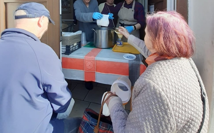 Osoby czekające na posiłek w punkcie pomocy.