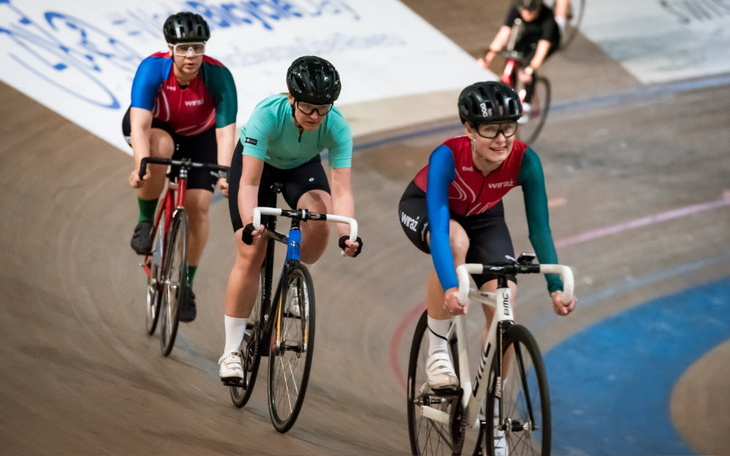 Trzy rowerzystki na torze wyścigowym.