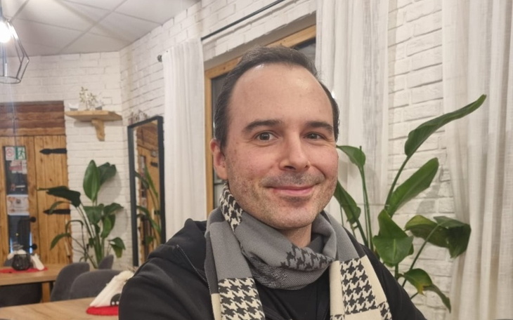 Mężczyzna uśmiechający się w kawiarni.