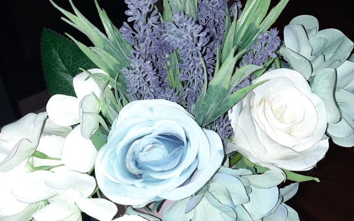 Bukiet sztucznych kwiatów w odcieniach bieli i fioletu.