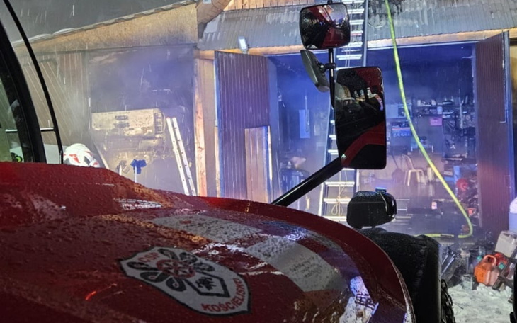 Widok na pożar w warsztacie, w tle widać drabinę.