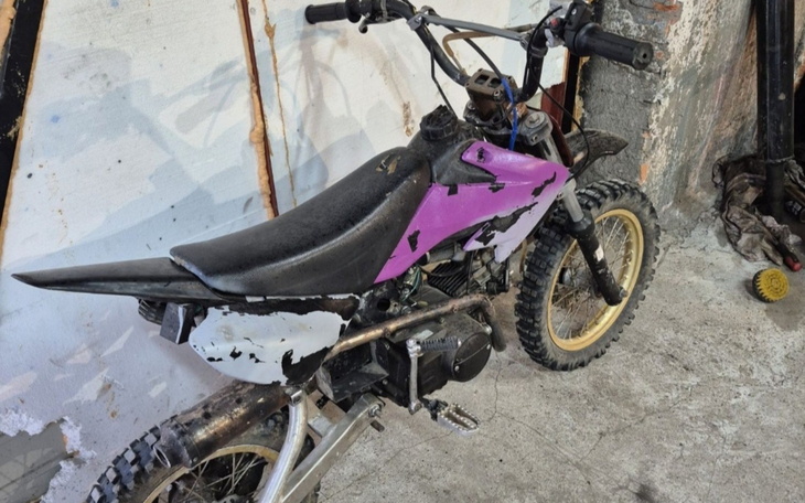 Motocykl w warsztacie, częściowo zniszczony.