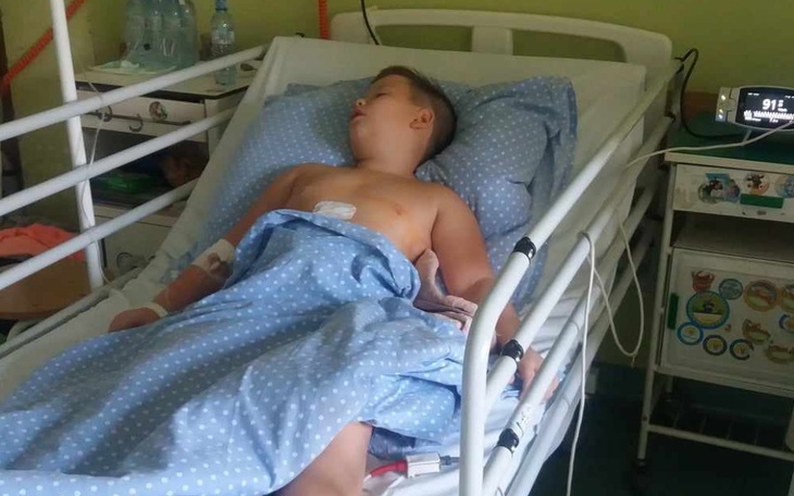 Chłopiec leżący w szpitalnym łóżku, z monitorem.