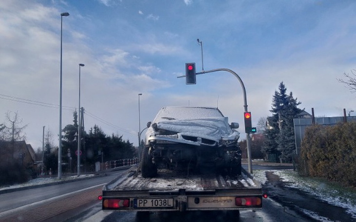 Zepsuty samochód na lawecie, pokryty śniegiem.