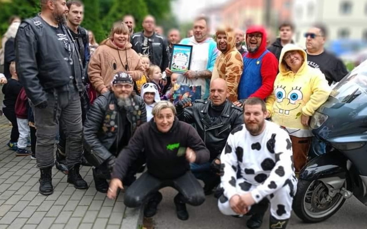 Grupa ludzi w kostiumach, pozująca do zdjęcia.