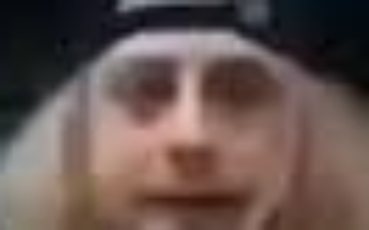 Rozmyty portret osoby z długimi włosami i czapką.