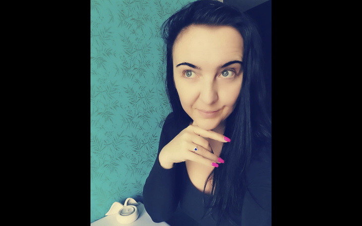 Kobieta z długimi włosami, uśmiechająca się do kamery.