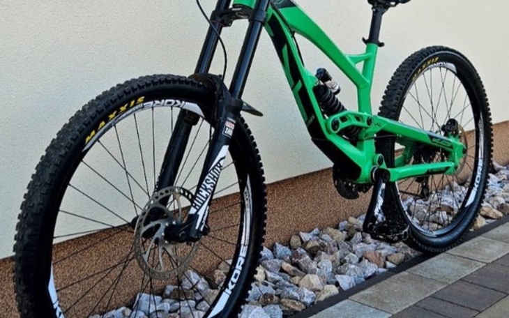 Zielony rower górski z widocznymi detalami na oponach.
