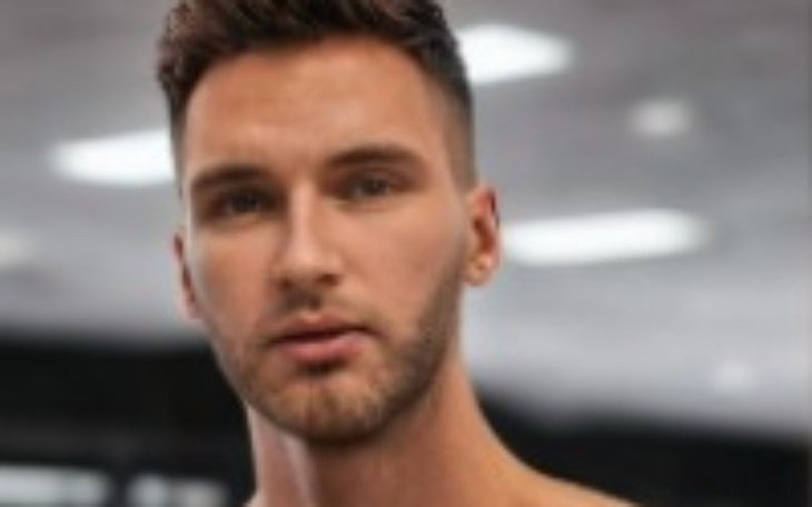 Mężczyzna w pomieszczeniu, z wyraźnym spojrzeniem.