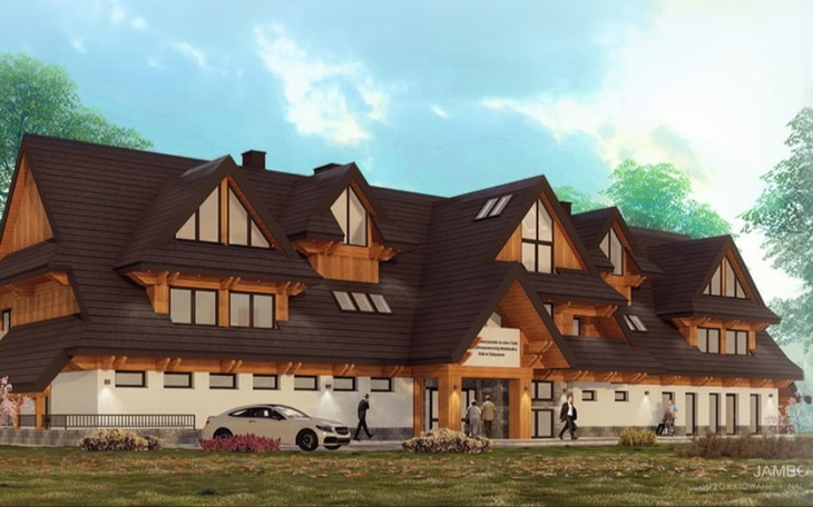 Nowoczesny budynek z drewnianymi elementami w otoczeniu zieleni.