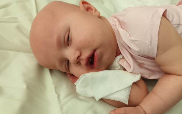 Małe dziecko śpiące na białej pościeli.