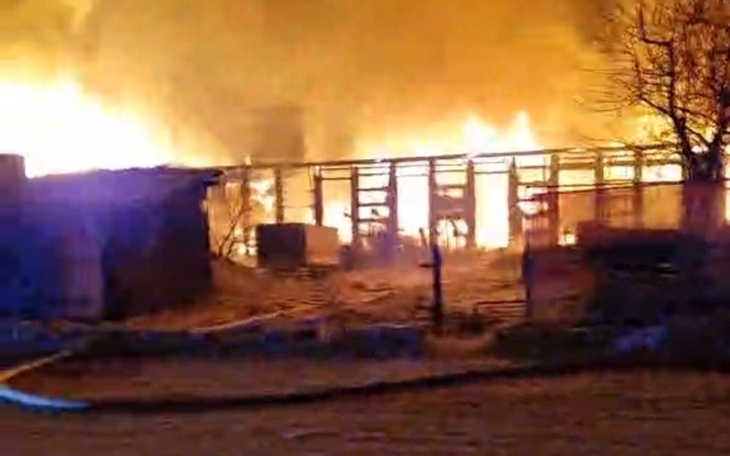 Płonący budynek, ogień i dym w nocy.