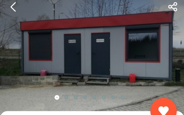 Modułowy budynek z dwiema drzwiami w szarej okolicy.