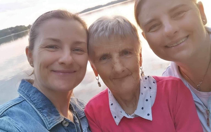 Trzy kobiety pozujące do zdjęcia nad jeziorem.