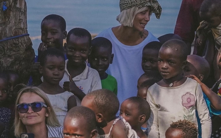 Grupa dzieci w towarzystwie dorosłych, uśmiechnięte twarze.