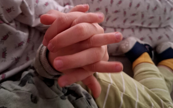 Dwie pary rąk dzieci trzymających się nawzajem.