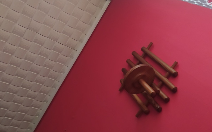 Widok sufitu z drewnianym żyrandolem na czerwonej ścianie.