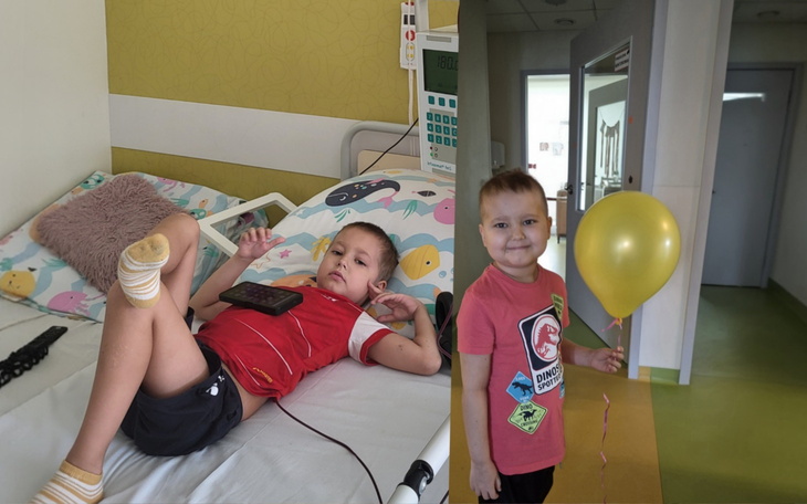 Dziecko w szpitalu, trzyma balon, uśmiechnięte.