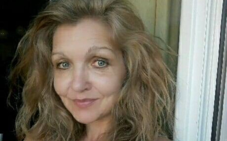 Portret kobiety z długimi, falującymi włosami i uśmiechem.