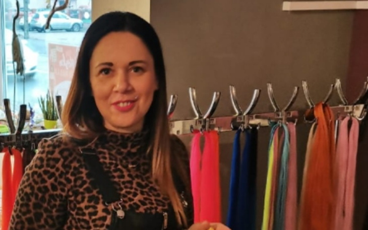 Kobieta w modnym ubraniu, trzymająca coś w ręku.