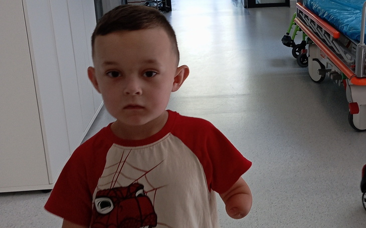 Karetka pogotowia, zaparkowana na drodze, z niebieskimi światłami.