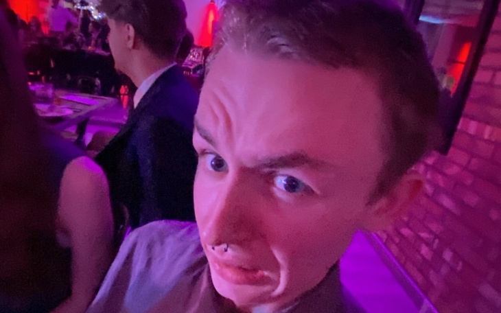 Mężczyzna z zaskoczoną miną w kolorowym oświetleniu.