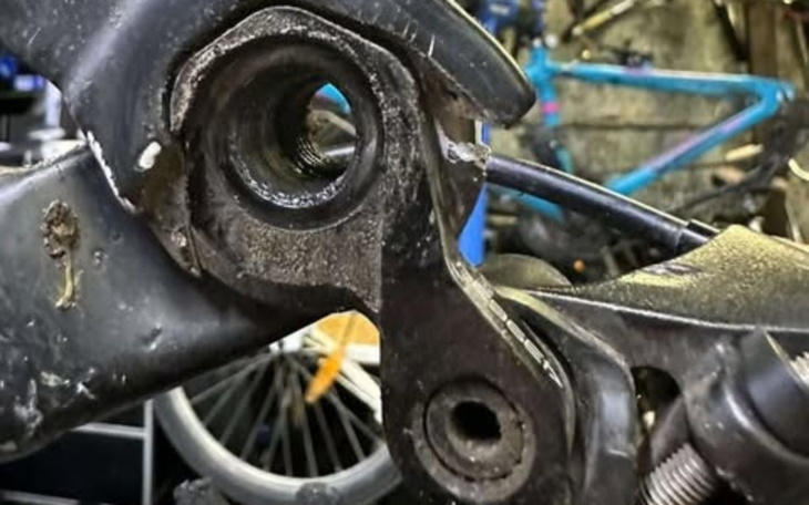 Uszkodzona część roweru w warsztacie.