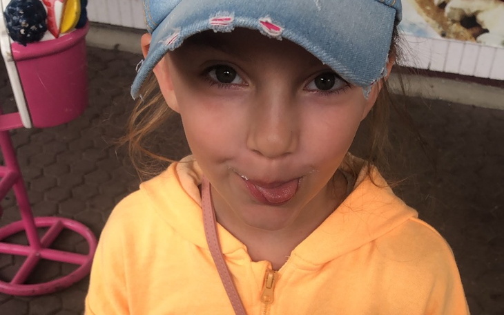 Dziewczynka w czapce, robiąca zabawną minę.