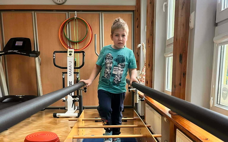 Chłopiec ćwiczący na sprzęcie rehabilitacyjnym.