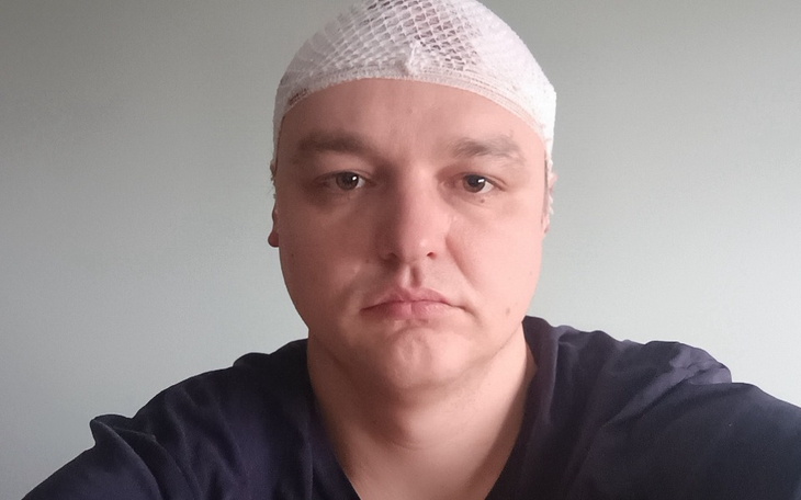 Mężczyzna z opatrunkiem na głowie.