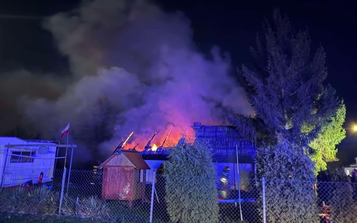 Pożar w budynku, dym i płomienie w nocy.