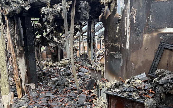 Zniszczony budynek po pożarze, z ruinami i popiołem w środku.