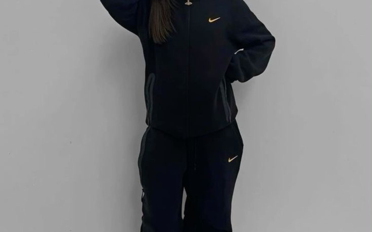 Dziewczyna w czarnym dresie pozująca do zdjęcia.