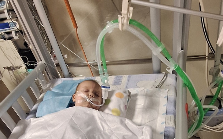 Dziecko w szpitalu, podłączone do aparatury medycznej.