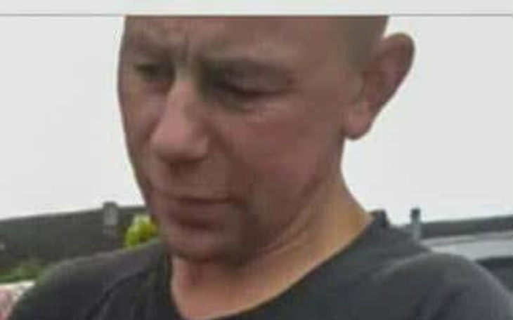 Mężczyzna z zamyśloną miną, patrzący w dół.