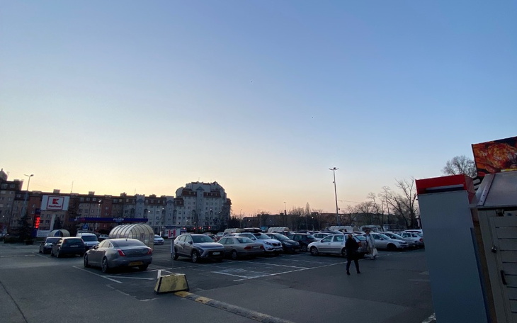 Widok parkingu z samochodami o zmierzchu.