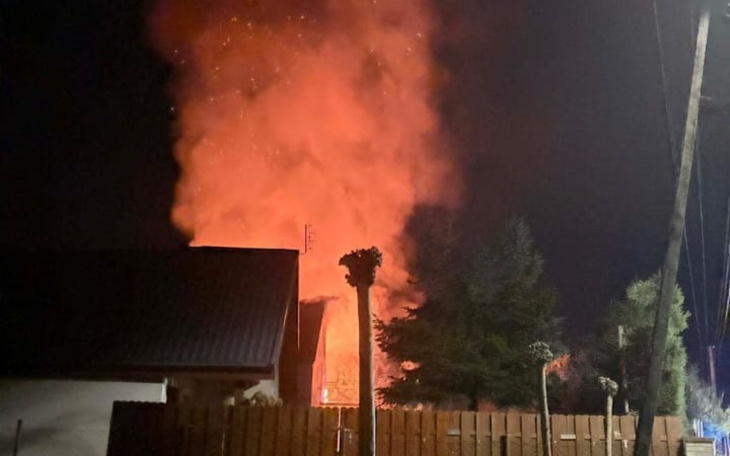 Pożar w nocy, ogień wydobywa się z budynku.