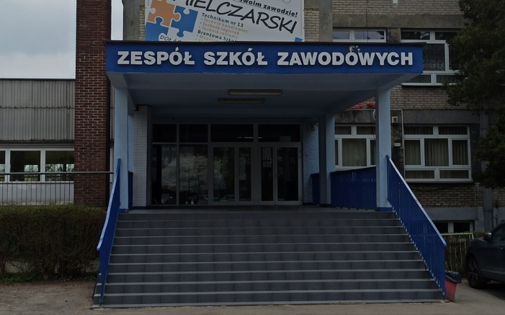 Wejście do Zespołu Szkół Zawodowych z niebieskimi schodami.